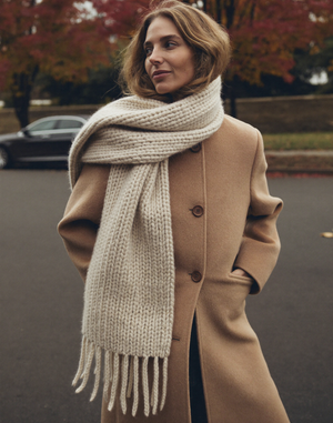 Women: woman in camel wool coat with knit scarf on an autumn street
